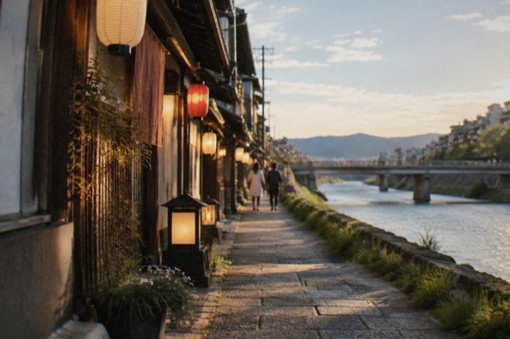 Evening lights and lanterns along a narrow stone alley beside the Kamo river in downtown Kyoto