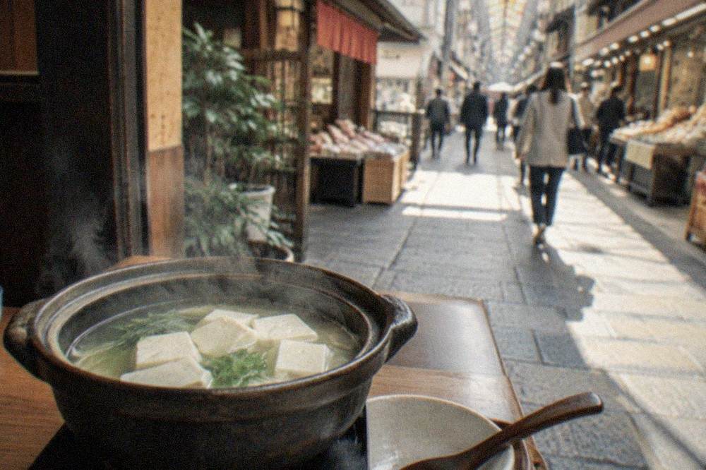 Simmering pot of tofu in clear broth on a low table in a wooden temple restaurant