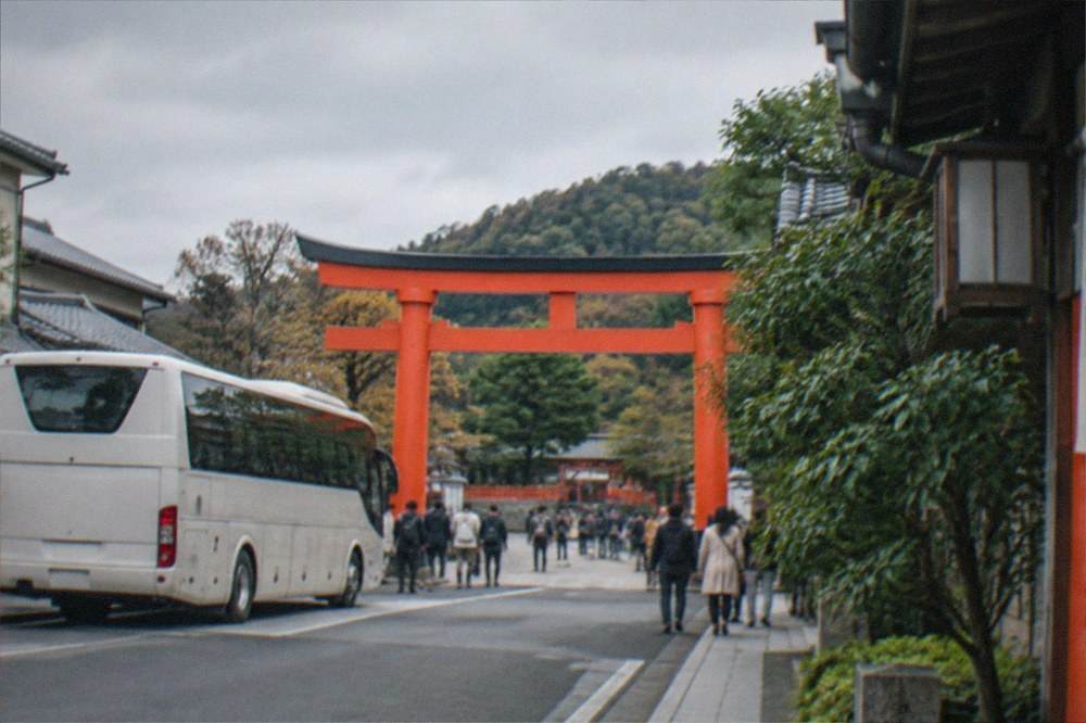 A tour bus parked near the entrance torii gate of Fushimi Inari shrine