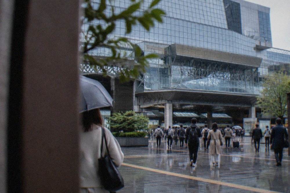 The modern glass facade of Kyoto Station seen from the plaza in front of the Karasuma central entrance