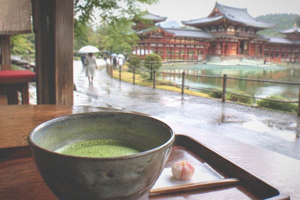 A bowl of whisked matcha tea served on a wooden tray in a Uji tea house