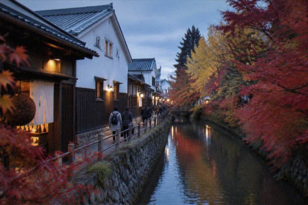 Brewery buildings along a canal with maple trees turning red in autumn