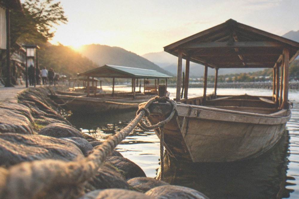 Wooden boats moored at a stone riverbank landing in soft morning light