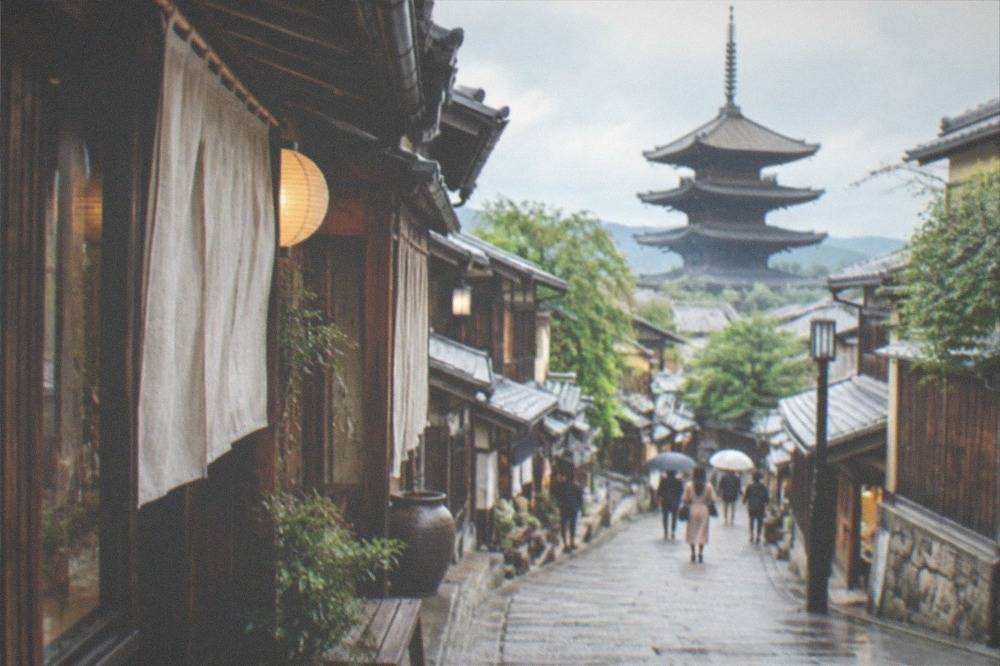 The stone-paved slope of Sannenzaka street lined with traditional wooden shopfronts leading toward the temple