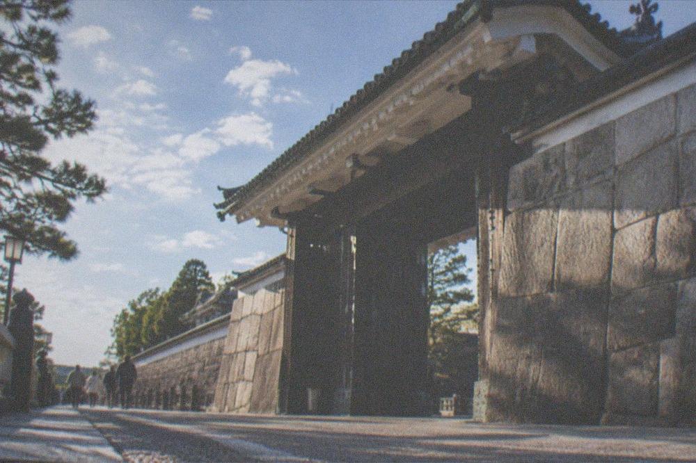 The stone wall and gate of Nijo-jo Castle under an afternoon sky