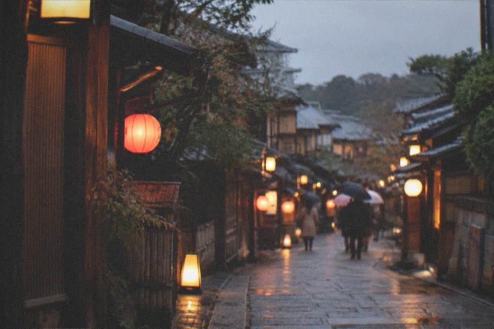 Lantern-lit stone paving in a Gion alley in the evening