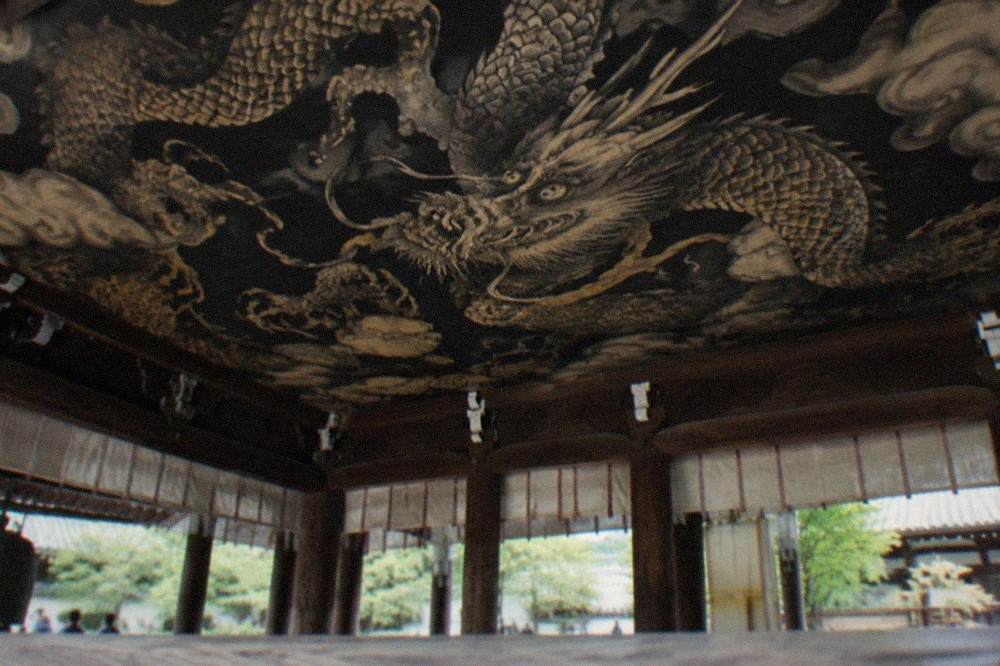 A painted dragon coiling across a dark temple ceiling