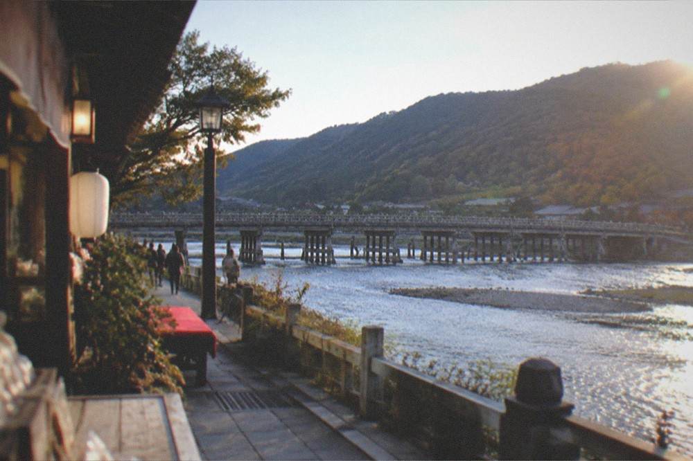 Togetsukyo bridge spanning a wide river with forested hills behind