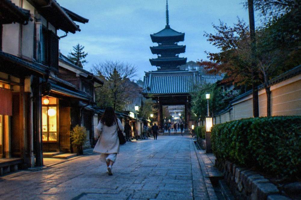 Stone path leading toward To-ji temple's gate with the pagoda visible beyond rooftops