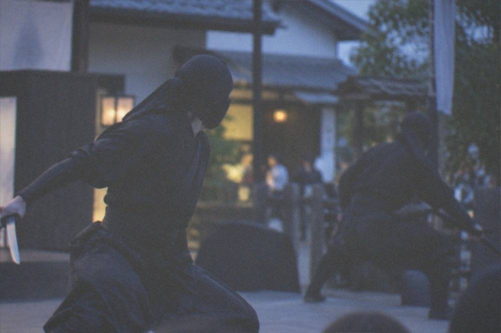 A ninja show performance with performers in black costumes on an outdoor stage