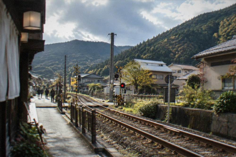 A rural railway line running between forested mountains in northern Japan