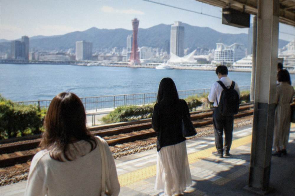 Passengers waiting on a clean suburban train platform in Japan