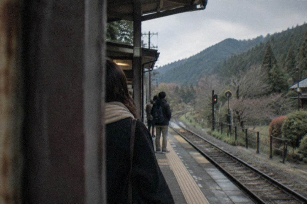 A train platform at a small rural mountain station surrounded by trees