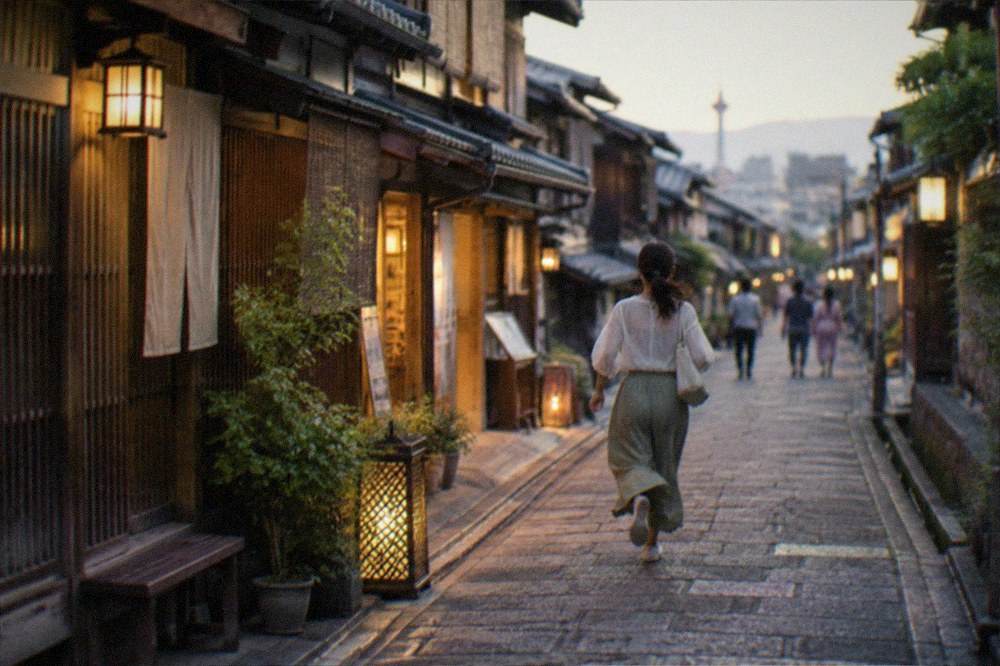 A stone-paved alley in Kyoto at dusk with traditional wooden facades and lanterns