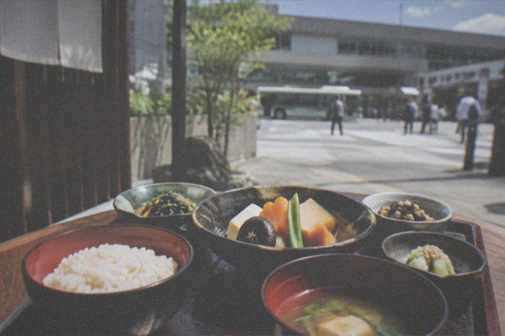 A vegan shojin-ryori tray with seasonal vegetables, tofu and rice in small lacquer bowls