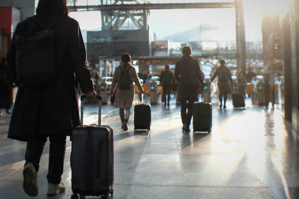 The wide concourse of Kyoto Station with travellers pulling suitcases toward the ticket gates