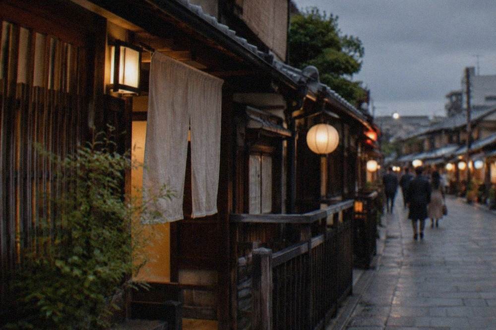 A lantern-lit wooden machiya street in Kyoto's Gion district in the evening
