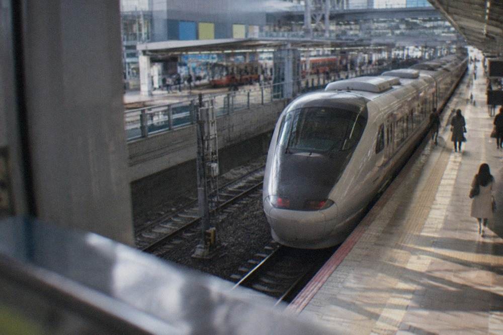 A sleek limited express train waiting at a platform inside a large airport rail station
