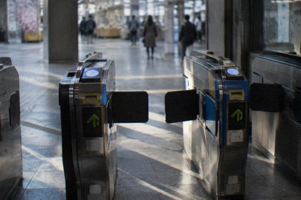 A row of ticket gates with IC card readers inside a Kyoto subway station
