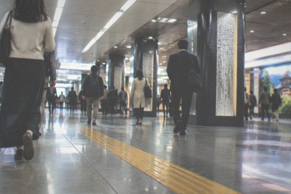 Commuters walking through a bright subway concourse beneath Kyoto Station