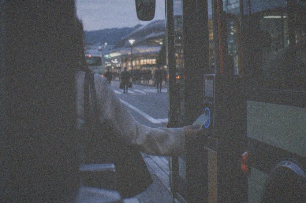 A passenger tapping a smart card on a bus reader board in Kyoto
