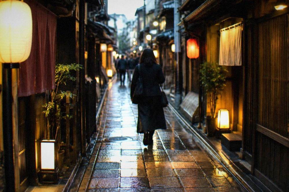 A narrow lantern-lit alley of small bar entrances in Kyoto at night
