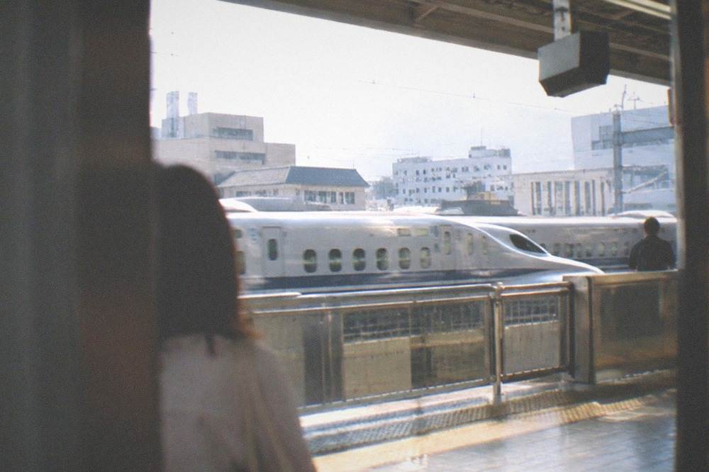 A rapid train departing a station platform in the Kansai region