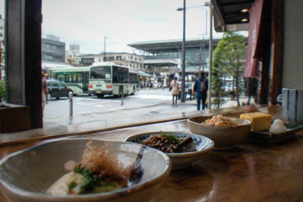 A sequence of small seasonal dishes arranged along a wooden counter