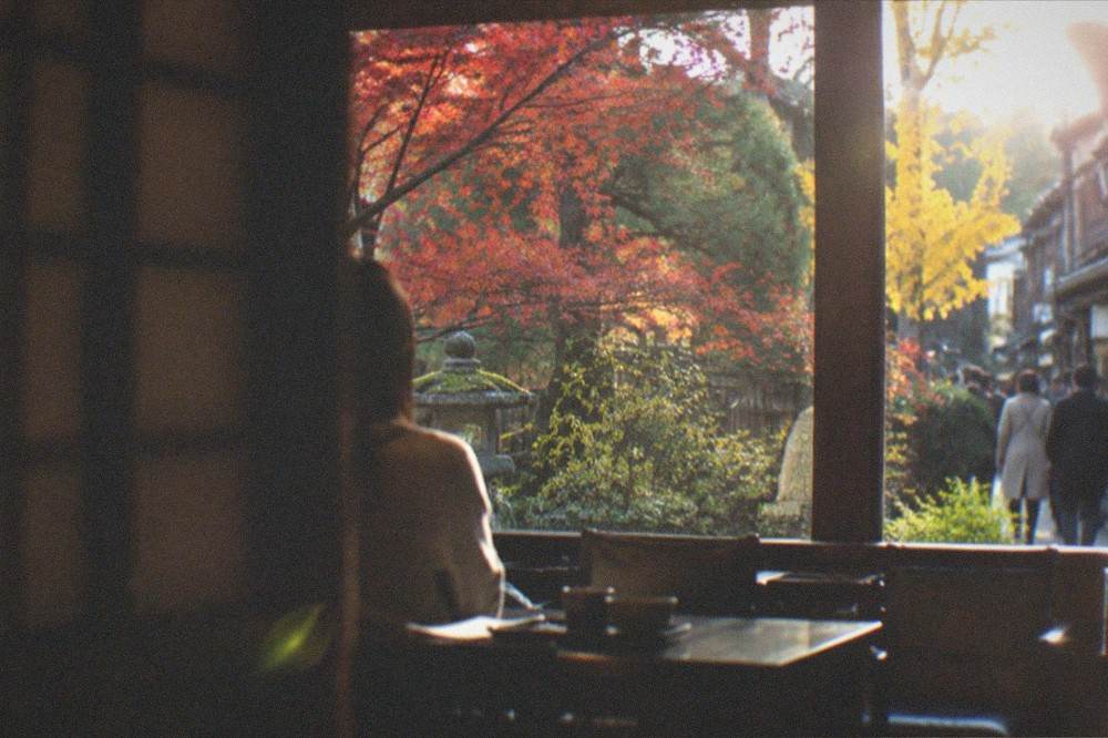 A dining room looking out onto a maple garden in late autumn