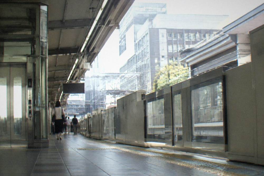 A modern subway platform in Kyoto with a lift and wide gates visible