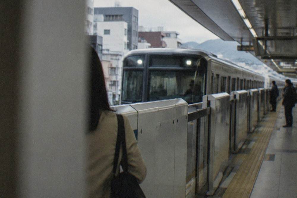 A subway train arriving at a clean modern Kyoto subway platform