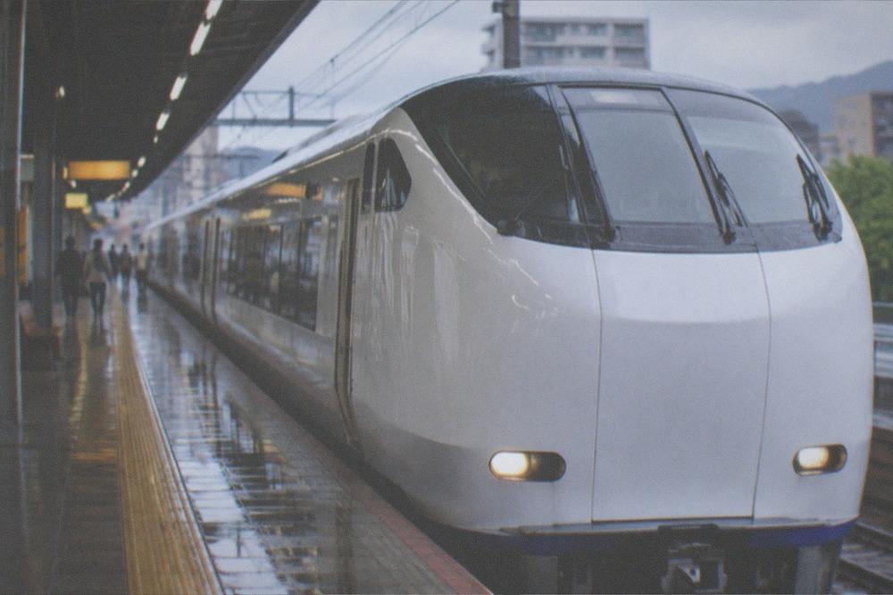 A white HARUKA express train waiting at an airport railway platform