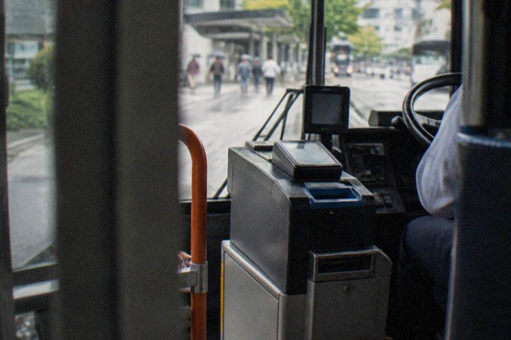 Close view of a Kyoto bus fare box and IC card reader beside the driver