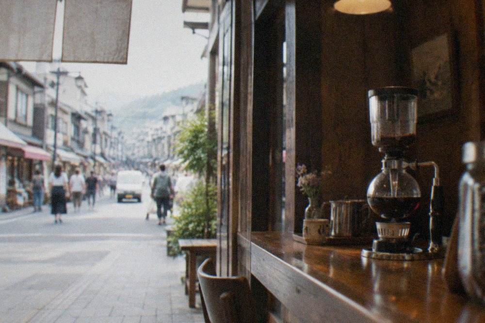 A wood-panelled Kyoto kissaten interior with a siphon coffee maker on the counter