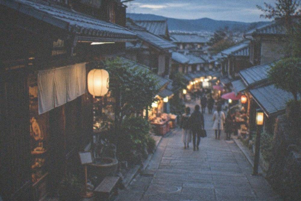 A stone-paved sloping lane in Higashiyama with traditional wooden machiya shopfronts