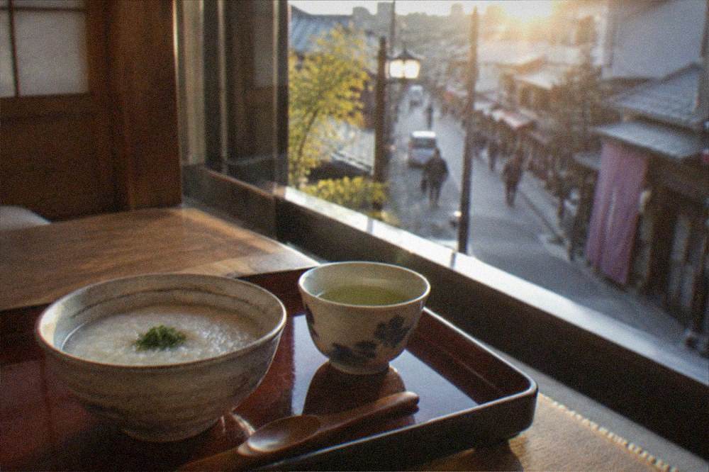 A lacquered tray with a small rice porridge bowl and tea served in a traditional room