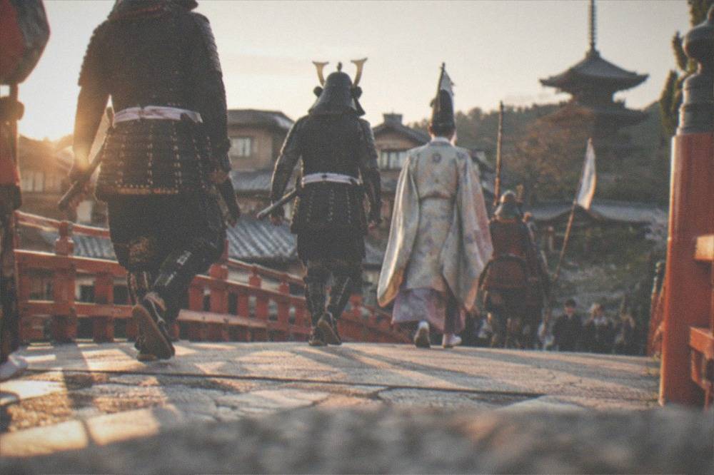 Marchers in historical armour and period costume crossing a bridge in Kyoto