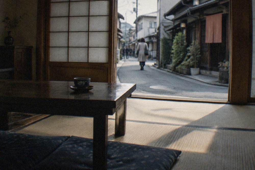 An interior tatami room of a wooden townhouse with sliding paper screens and a low wooden table