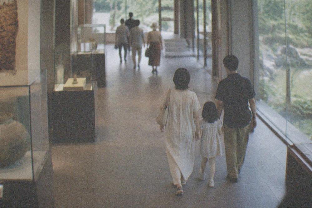 Family walking through a museum corridor with exhibits on both sides