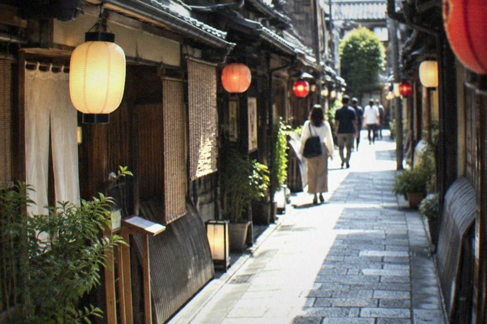 A narrow lantern-lit alley in Pontocho with traditional wooden restaurant fronts