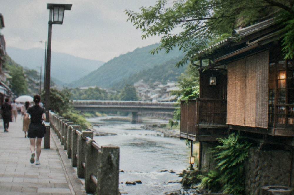 A wooden bathhouse building beside a river in a wooded mountain valley