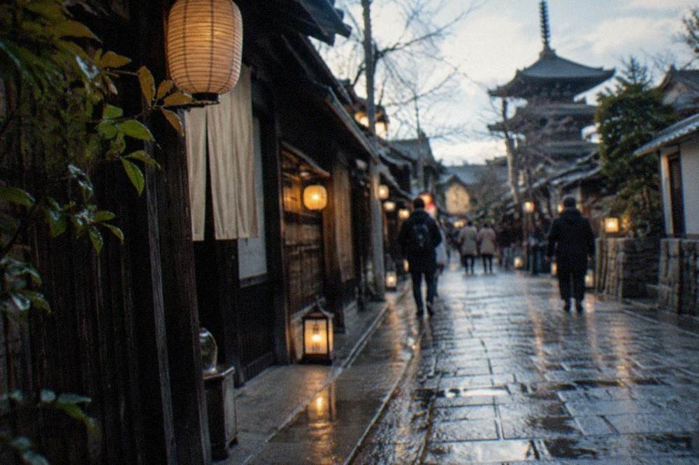 Wet stone paving reflecting lantern light on a narrow temple approach street in Kyoto