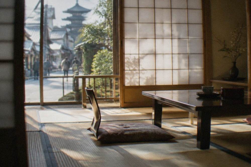A traditional Kyoto ryokan room with tatami flooring, a low table, and paper shoji screens