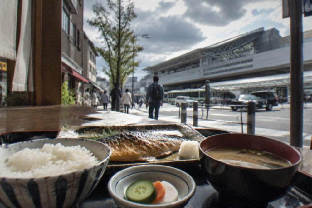 A Japanese breakfast set with grilled fish, rice, miso soup, and pickled vegetables on a lacquer tray