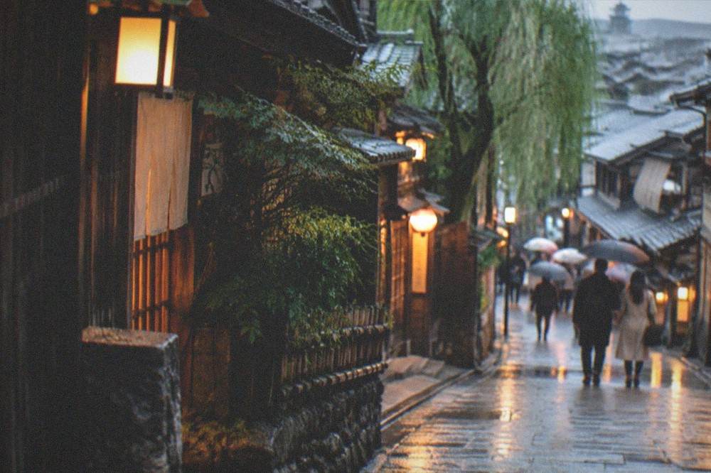 A lantern-lit stone lane in the Gion district of Kyoto in the early evening