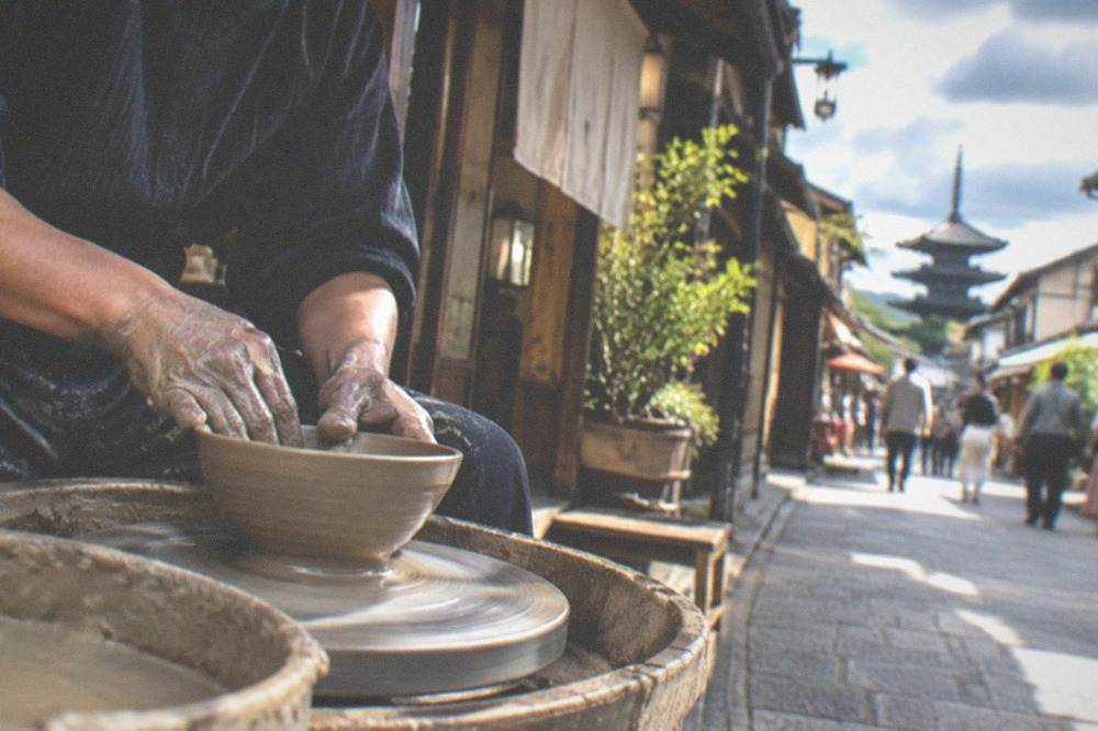 A potter shaping a clay bowl on a spinning wheel
