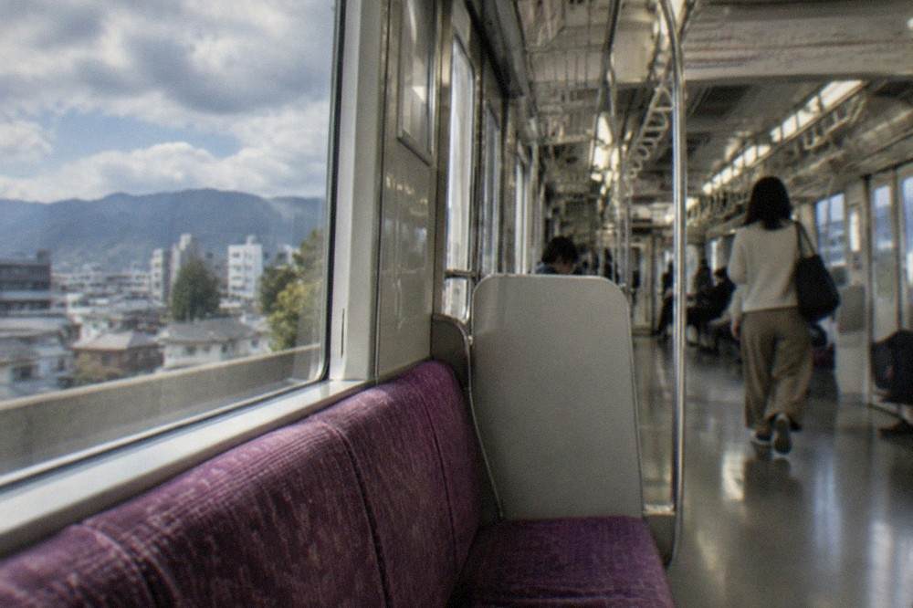 A Kyoto subway train interior with priority seating and overhead route map