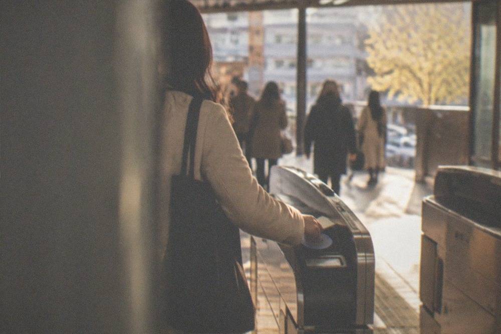 A commuter tapping an IC card on a Kyoto subway fare gate
