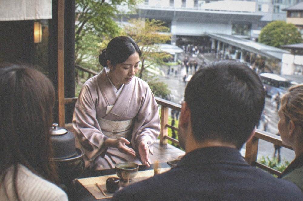 A host explaining tea etiquette to English-speaking guests