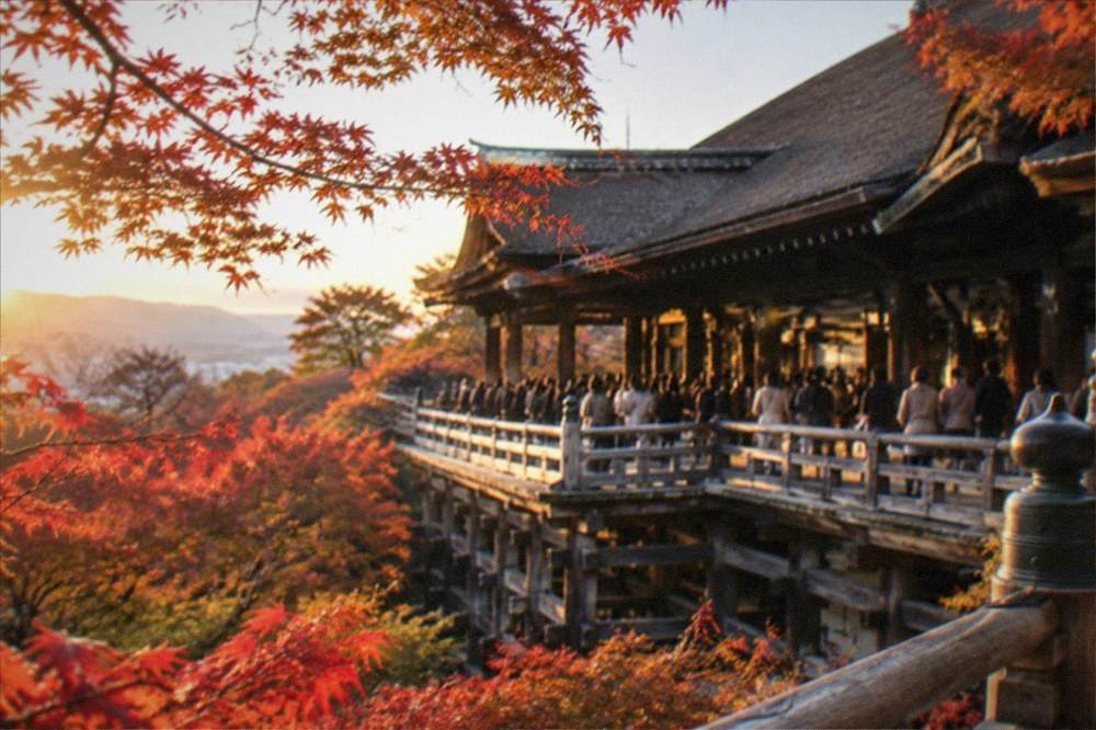 Maple trees overhanging the wooden Tsutenkyo bridge at Tofuku-ji with visitors along the walkway